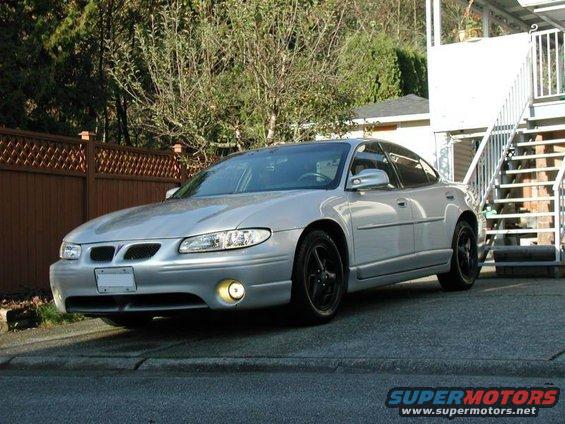 Silver 2002 Pontiac Grand Prix sedan parked on a driveway with black wheels