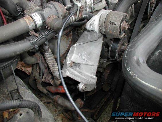 Close-up of an engine's alternator bracket and pulley system