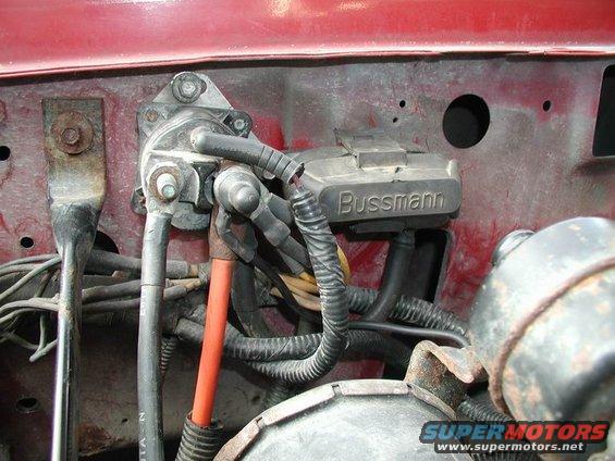 Close-up of vehicle's fuse box and wiring, showing a Bussmann component