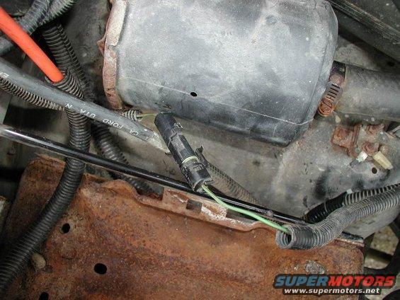 Engine bay wiring harness with green wires and a black connector