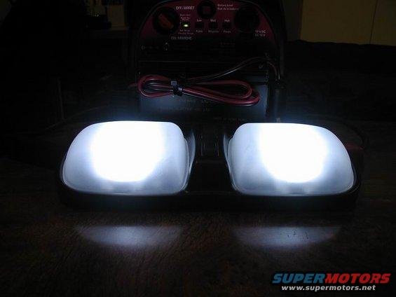 Two bright white dome lights are on, with a battery charger behind them
