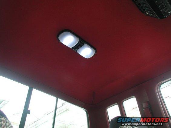 Red interior ceiling with dual dome lights and a black overhead console