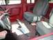 1990 Ford F-250 - The interior of a truck shows red door panels and gray fabric seats with seatbelts lying on the floor.