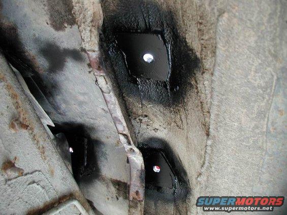 Close-up of underbody frame mounts with black spray paint