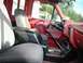 1990 Ford F-250 - The interior of a red Ford F-250 shows grey cloth seats and a black center console with a floor shifter.
