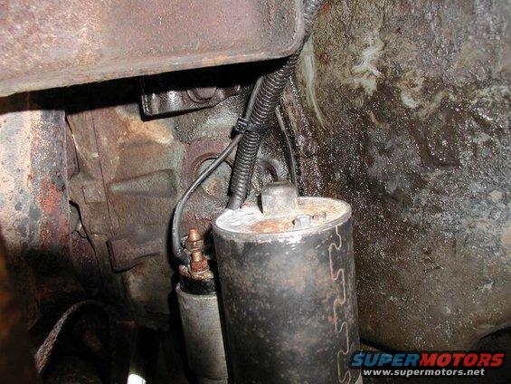 Starter motor assembly attached to transmission housing