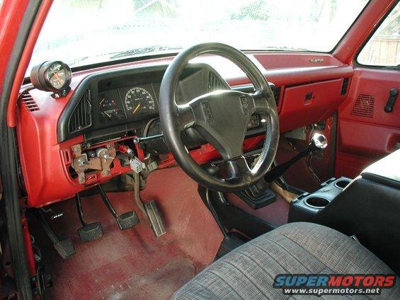 1990 Ford F-250 interior showing dashboard, steering wheel, pedals, and aftermarket gauge