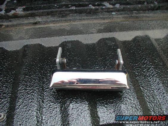Chrome tailgate handle mounted on a black truck bed liner