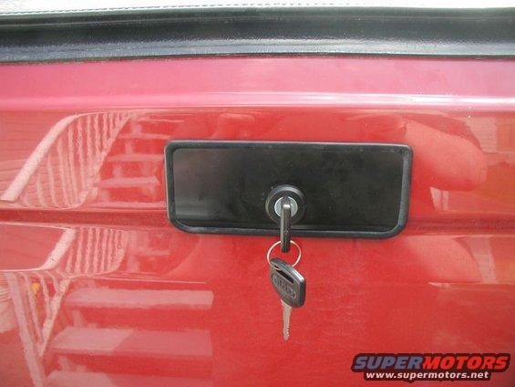 Red tailgate with black lock and keys. Text 'SUPERMOTORS' visible