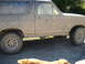 1990 Ford Bronco - This 1990 Ford Bronco is heavily covered in mud, obscuring its original paint and details.