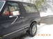 1990 Ford Bronco - A 1990 Ford Bronco is shown in a snowy outdoor setting with the driver visible through the window.