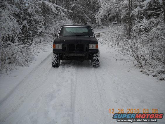 Black Ford Bronco with aftermarket wheels on a snowy road