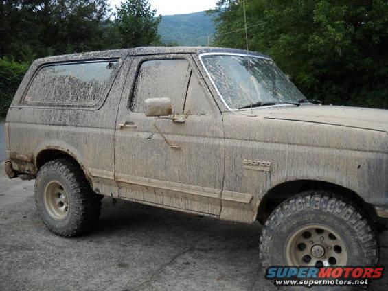 Mud-covered 1990 Ford Bronco, 3/4 front view, showing side and front fender