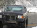 1990 Ford Bronco - This dark SUV, seen in a snowy environment, has a missing front grille and appears to be from around 1990, though its exact model is uncert…