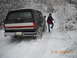 1990 Ford Bronco - 1990 Ford Bronco driving through snow with a person standing nearby.