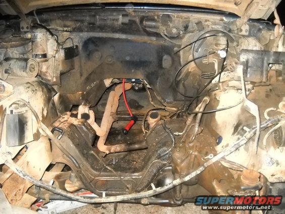 Engine bay with exhaust manifold and red spark plug wire