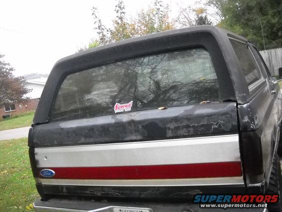 Black Ford Bronco rear, silver and red stripe, cracked paint, Summit sticker on rear window