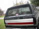 1990 Ford Bronco - Rear view of a black Ford Bronco with a distinctive stripe and a Summit sticker on the window.