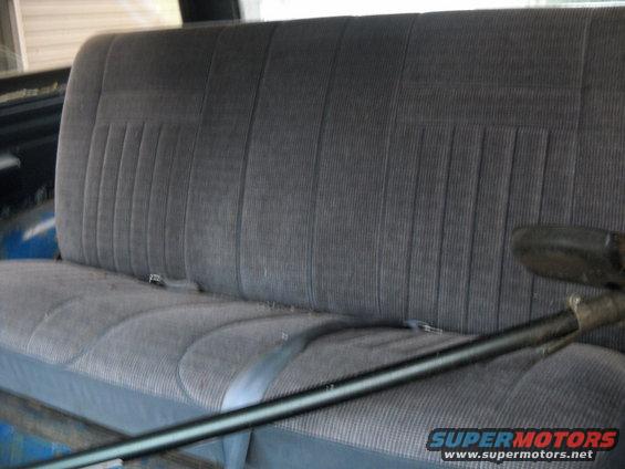 gray fabric bench seat with seatbelts inside a vehicle
