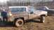 1995 Ford Bronco - This muddy SUV, likely from the 1970s, is stuck in the mud with another truck nearby.