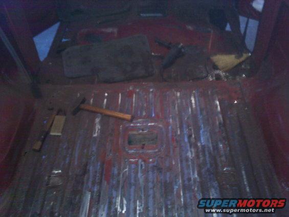 Interior cargo area of a vehicle with a hammer and some wood blocks on the floor