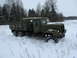 1987 Ford Bronco - A military truck is stuck in a snowy field with trees in the background.