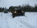 1987 Ford Bronco - Two military trucks navigate a snowy field with trees in the background.