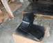 1976 Ford Ranchero - A black car part is being spray painted black, resting on a cardboard box.