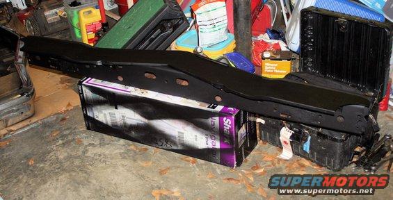 Black metal part resting on a box and a black container