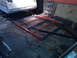 1984 Ford Bronco - Metal frame construction for a trailer is underway, with various tools and materials scattered around the workshop floor.