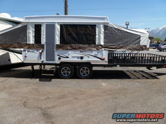 Side view of a white Rockwood toy hauler with a ramp