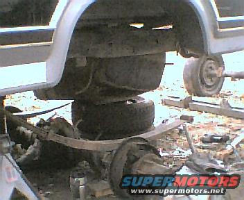Vehicle rear axle, leaf springs, and fuel tank assembly. SuperMotors logo visible