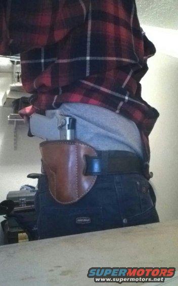 Brown leather holster with handgun on hip