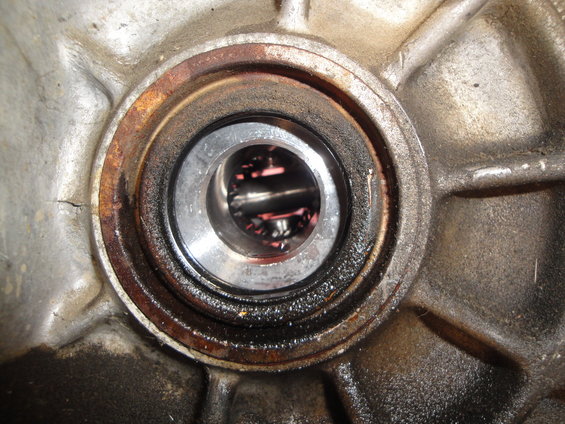 Close-up of a transmission input shaft seal with some rust and oil