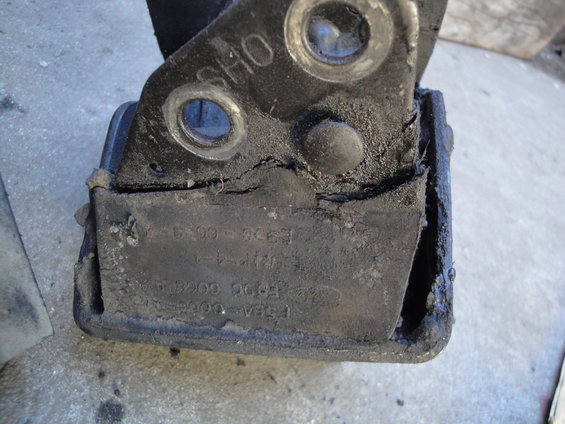 Worn engine mount with visible Ford part numbers and "SHO" marking