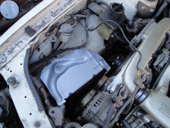 1992 Ford Taurus engine bay with a gray clutch cover and alternator