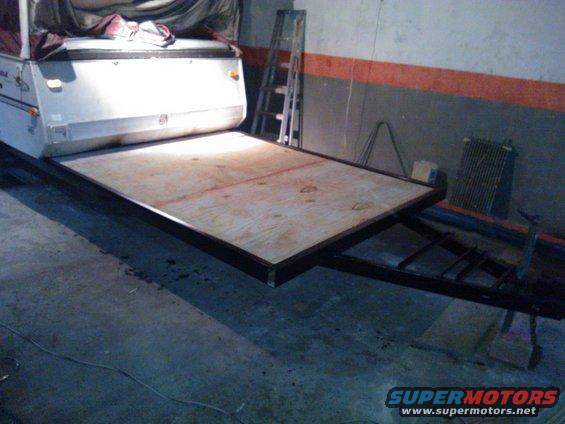 Pop-up camper trailer bed with plywood surface