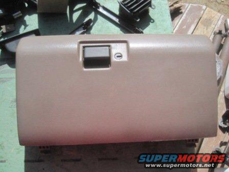 Tan glove box door with a gray latch and a keyhole