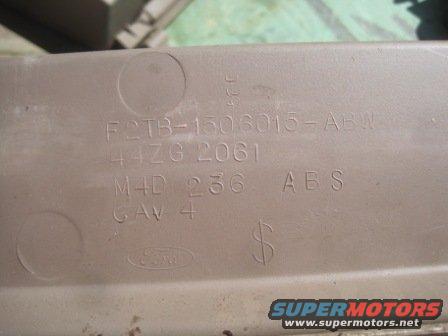 Close-up of a beige plastic part with embossed text: F2TB-1506015-ABW, 44ZG 2061, M4D 236 ABS, GAV 4, and a Ford logo