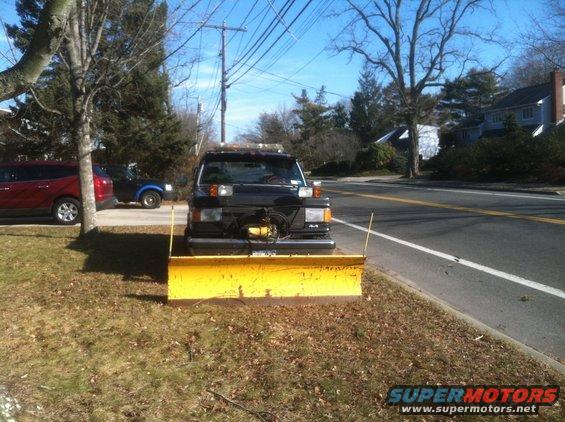 Black truck with yellow snow plow and 4x4 badge