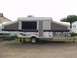 1984 Ford Bronco - A pop-up camper trailer is parked outdoors, with its canvas sections extended.