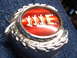 1973 Ford Ranchero - A close-up of a vehicle emblem with a red background and chrome lettering.
