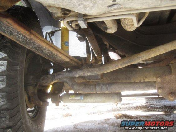 Underside view of a truck's suspension and drivetrain components. Shows a Bilstein shock absorber