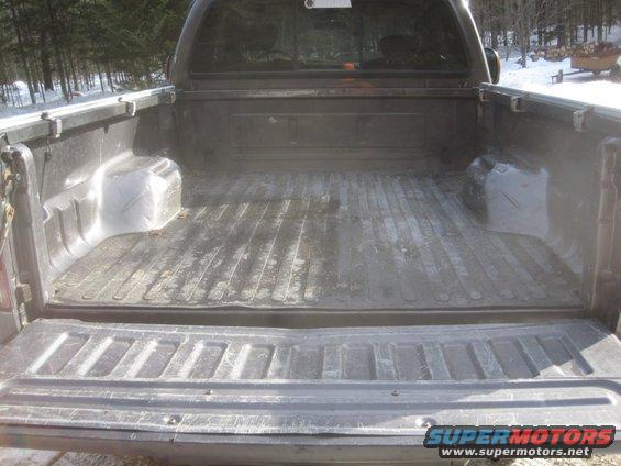 Rear view of a 2003 Ford F-350 truck bed with a spray-in liner
