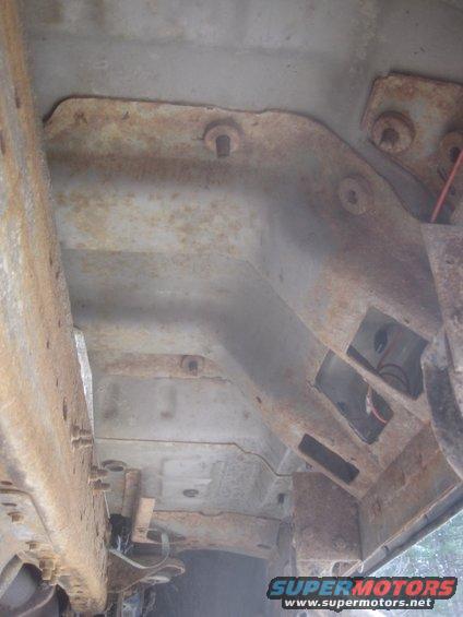 Underside of a rusty vehicle frame with some wiring visible