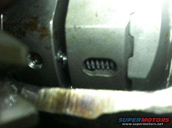 Close-up of a metal mechanical part, possibly from a transmission or differential, showing a spring mechanism