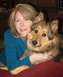 2012 Ford Focus - A woman smiles while holding a dog in front of a blurred background of furniture.