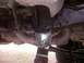 1994 Ford Bronco - Close-up of vehicle suspension and exhaust components, showing a U-joint and mounting brackets.
