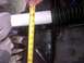 1994 Ford Bronco - Close-up view of a shock absorber and suspension parts, with a tape measure indicating length.