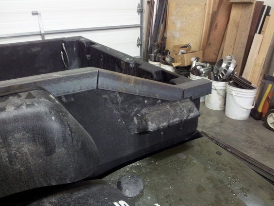 Close-up of a modified truck bed with metal reinforcements and black plastic fender flares